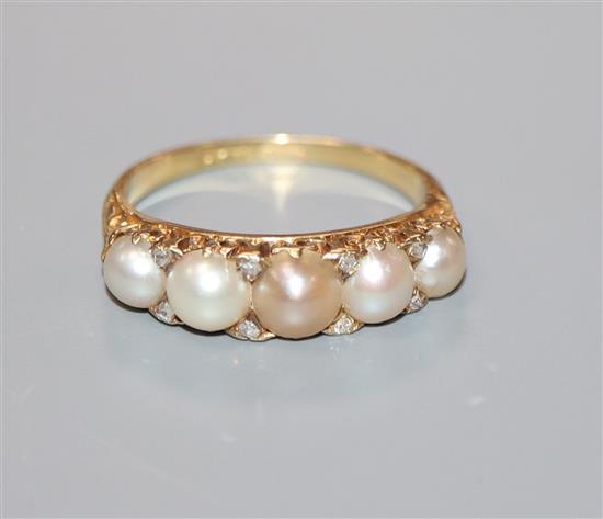 An early 20th century 18ct, graduated split pearl five stone ring, with diamond chip spacers, size M.